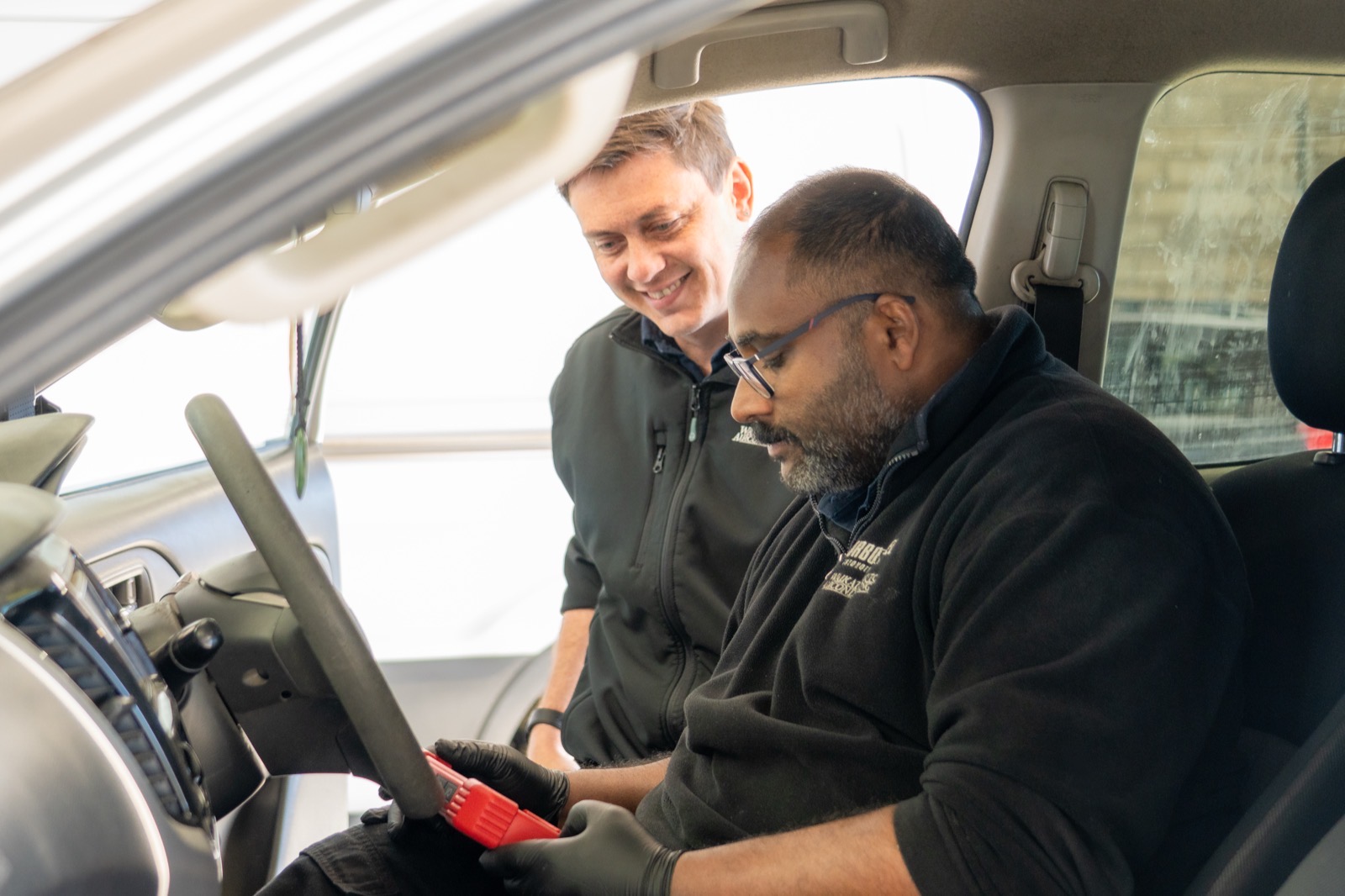 A smiling customer looking over live scan data with a Turbo & Diesel technician.